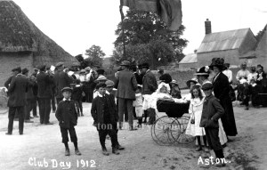 Taken in 1912 at the Aston Club Day, a group of adults and children stand and a band play.
