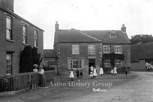 Taken in the early 20th century, a group of adults and children outside the Red Lion public house in The Square, Aston.